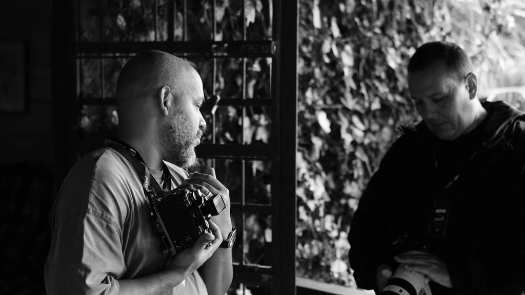 The UniquePers writing room in Lisbon, mid-session, black-and-white documentary photograph.