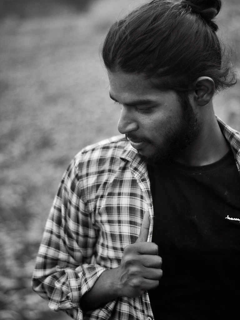 Black-and-white editorial portrait of a deep-tech founder against a diagrammed whiteboard with a warm accent overlay.